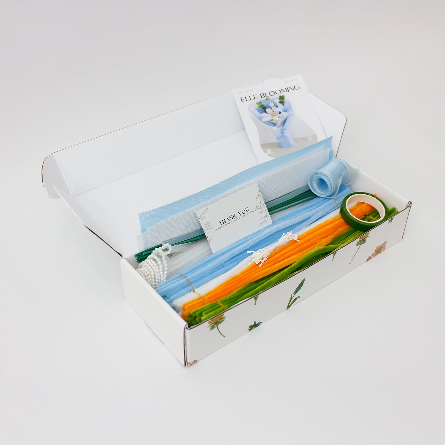 Baby Blue Lilies DIY bouquet made from soft pipe cleaners, featuring delicate white and blue lilies with greenery. Wrapped in pastel blue paper with a sheer ribbon a serene, handmade gift for any occasion.