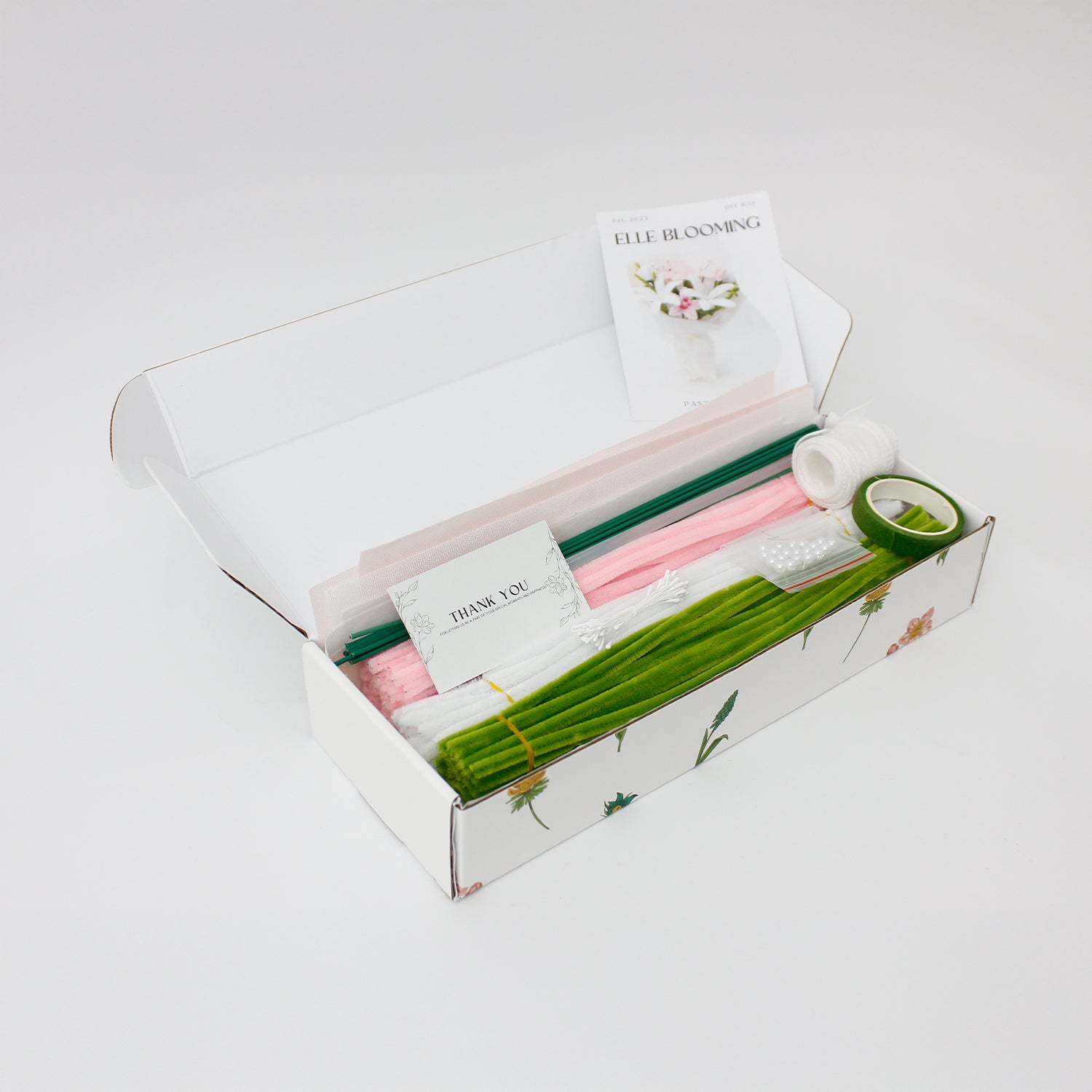 Pastel Bloom DIY bouquet crafted from pipe cleaners, featuring soft white and blush pink lilies, tulips, and delicate filler flowers. Wrapped in sheer pastel wrapping with a flowing organza ribbon an elegant, handmade floral craft kit for gifting or display.