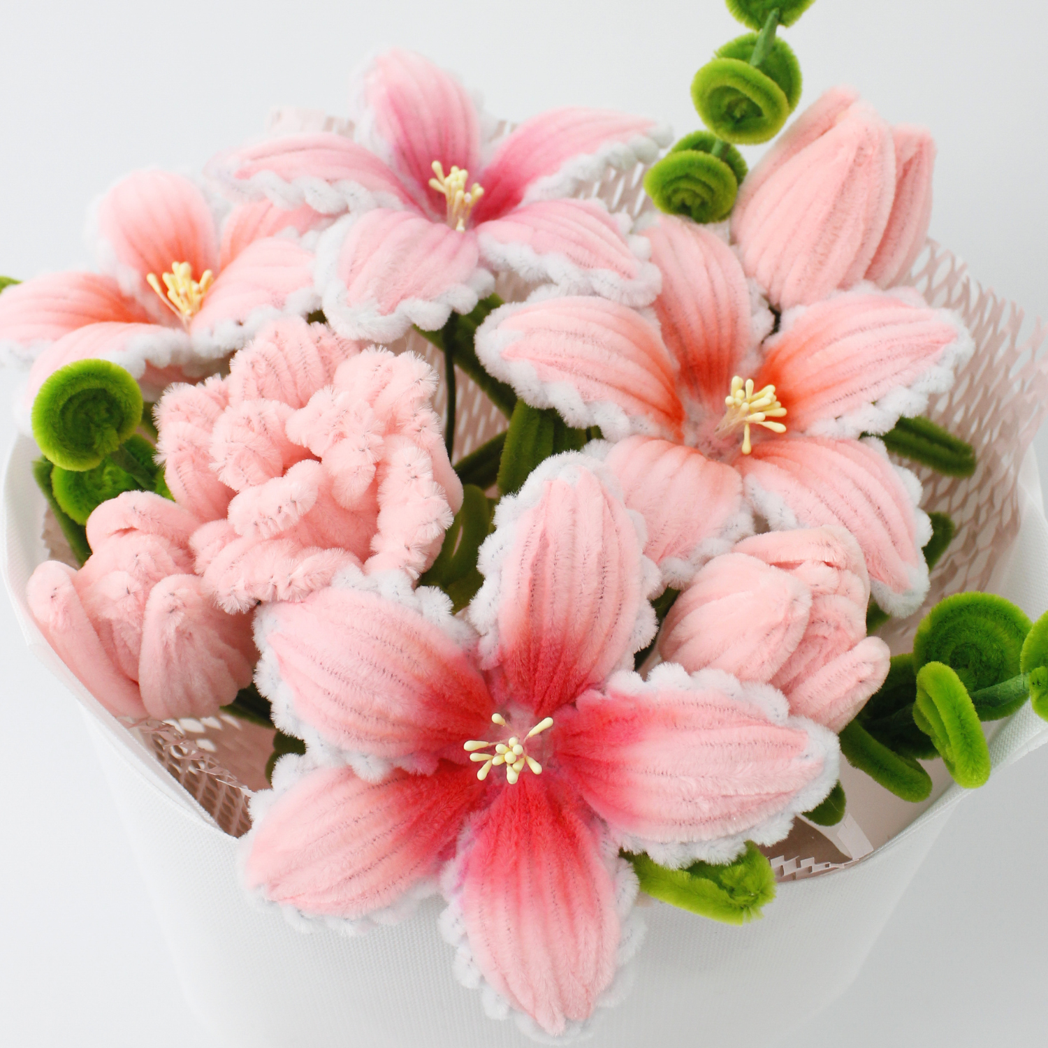 Elegant pink lily bouquet handcrafted from fuzzy pipe cleaners, featuring soft textures and charming pastel tones. A perfect handmade gift for home decoration, birthdays, or heartfelt surprises.
