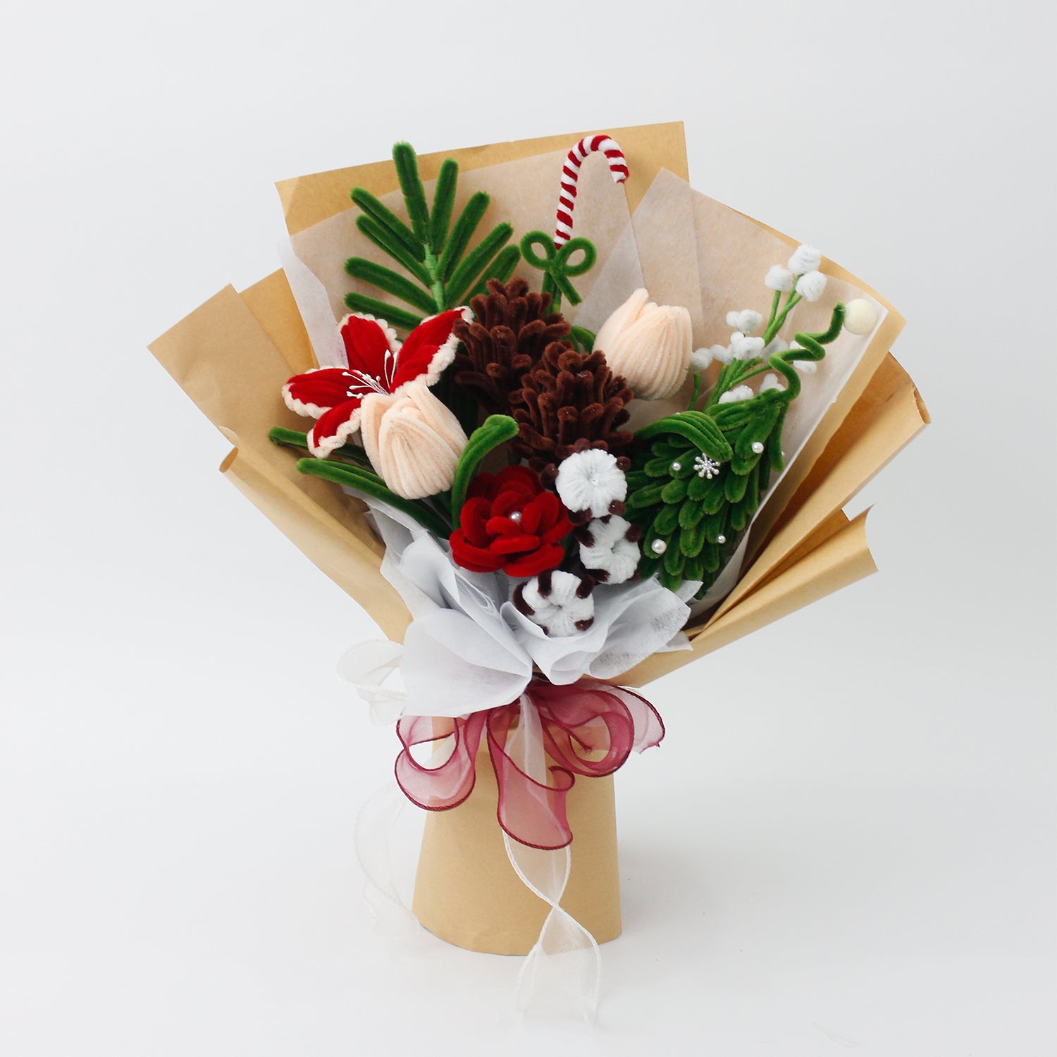 DIY flower bouquet kit "Winter Whispers" featuring handmade pinecones, red lily, candy cane, tulips, and cotton flowers made from pipe cleaners. Perfect for Christmas crafting or gifting.