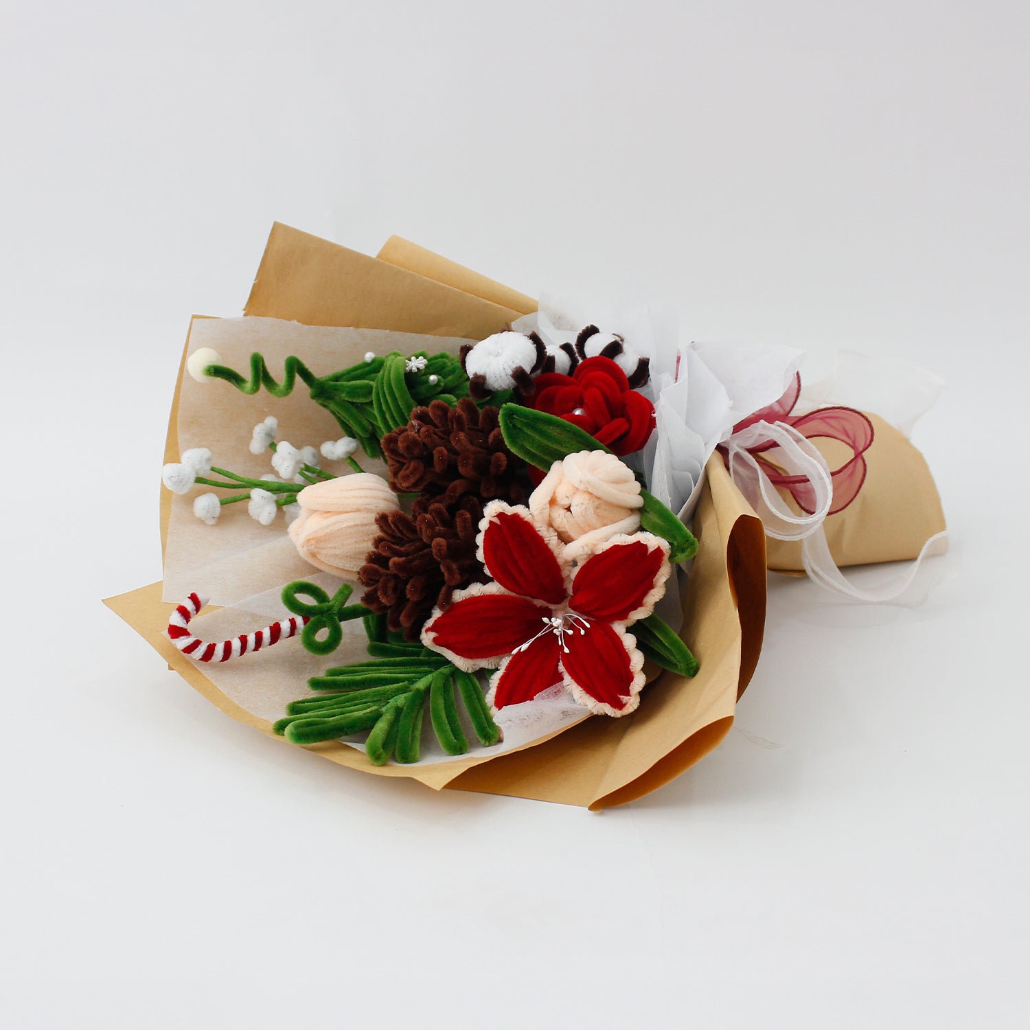 DIY flower bouquet kit "Winter Whispers" featuring handmade pinecones, red lily, candy cane, tulips, and cotton flowers made from pipe cleaners. Perfect for Christmas crafting or gifting.