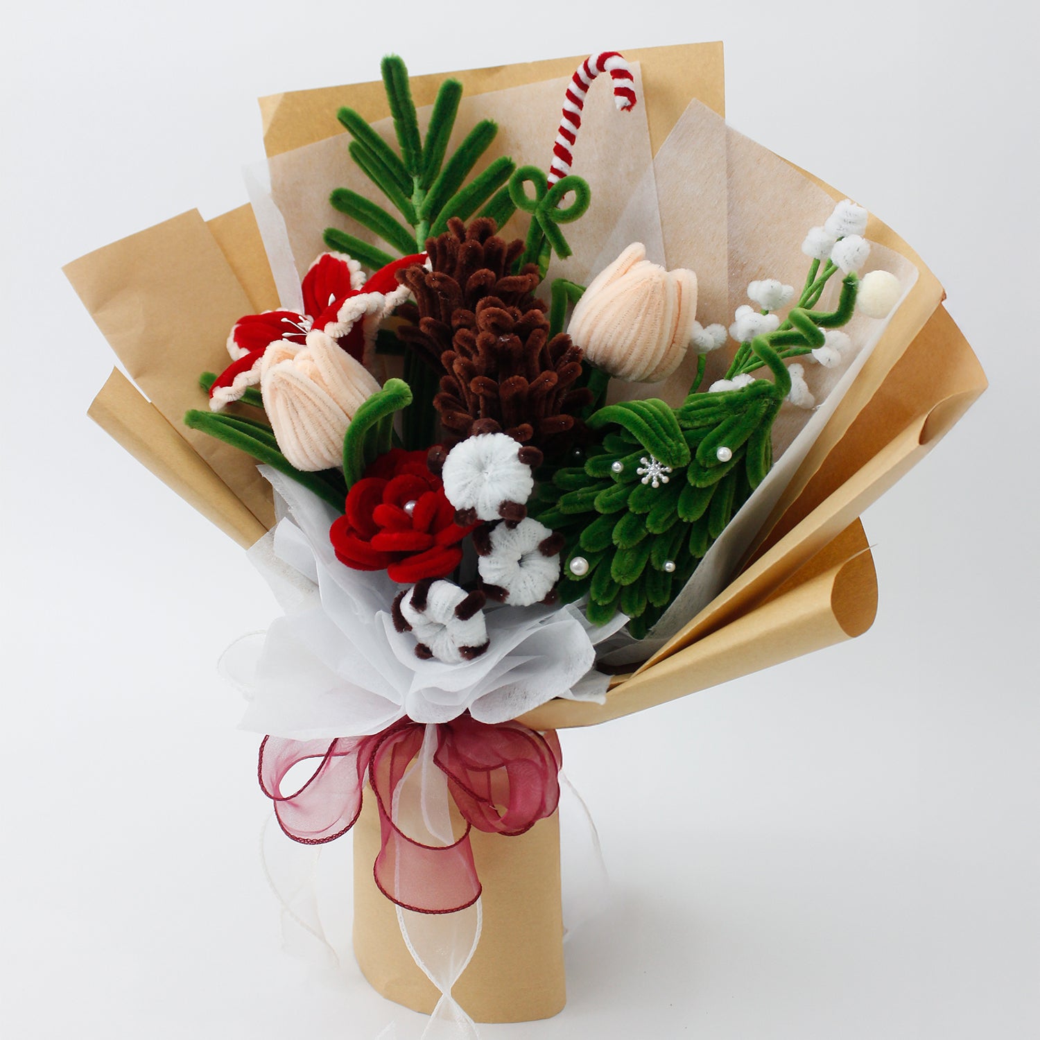 DIY flower bouquet kit "Winter Whispers" featuring handmade pinecones, red lily, candy cane, tulips, and cotton flowers made from pipe cleaners. Perfect for Christmas crafting or gifting.