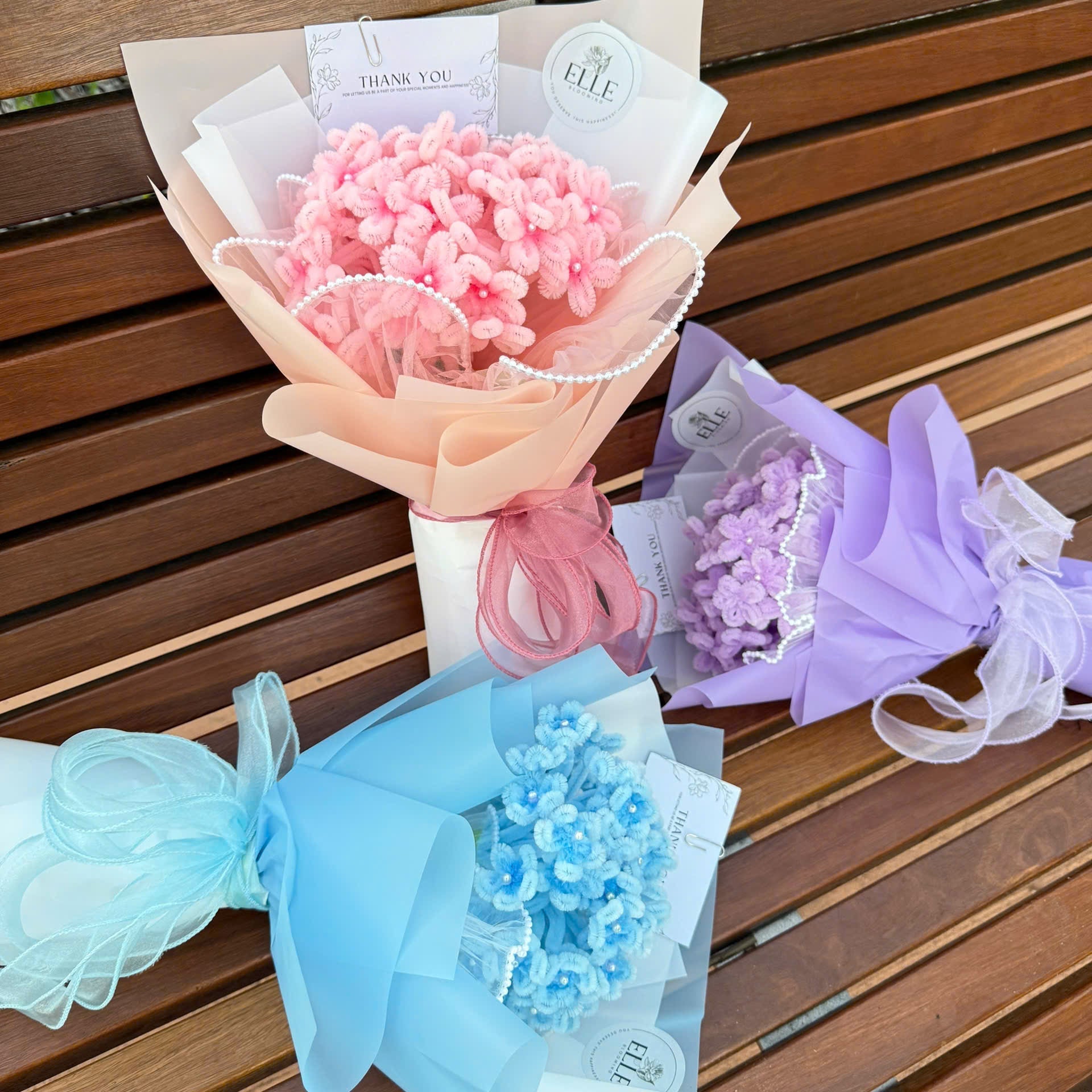 Three colorful bouquets of flowers on a wooden surface