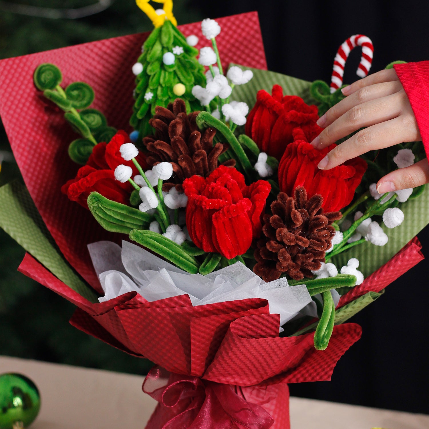 Handmade bouquet with green and white pipe cleaner flowers, wrapped in rich dark green paper and ribbon. Elegant evergreen design perfect for Christmas and winter décor.