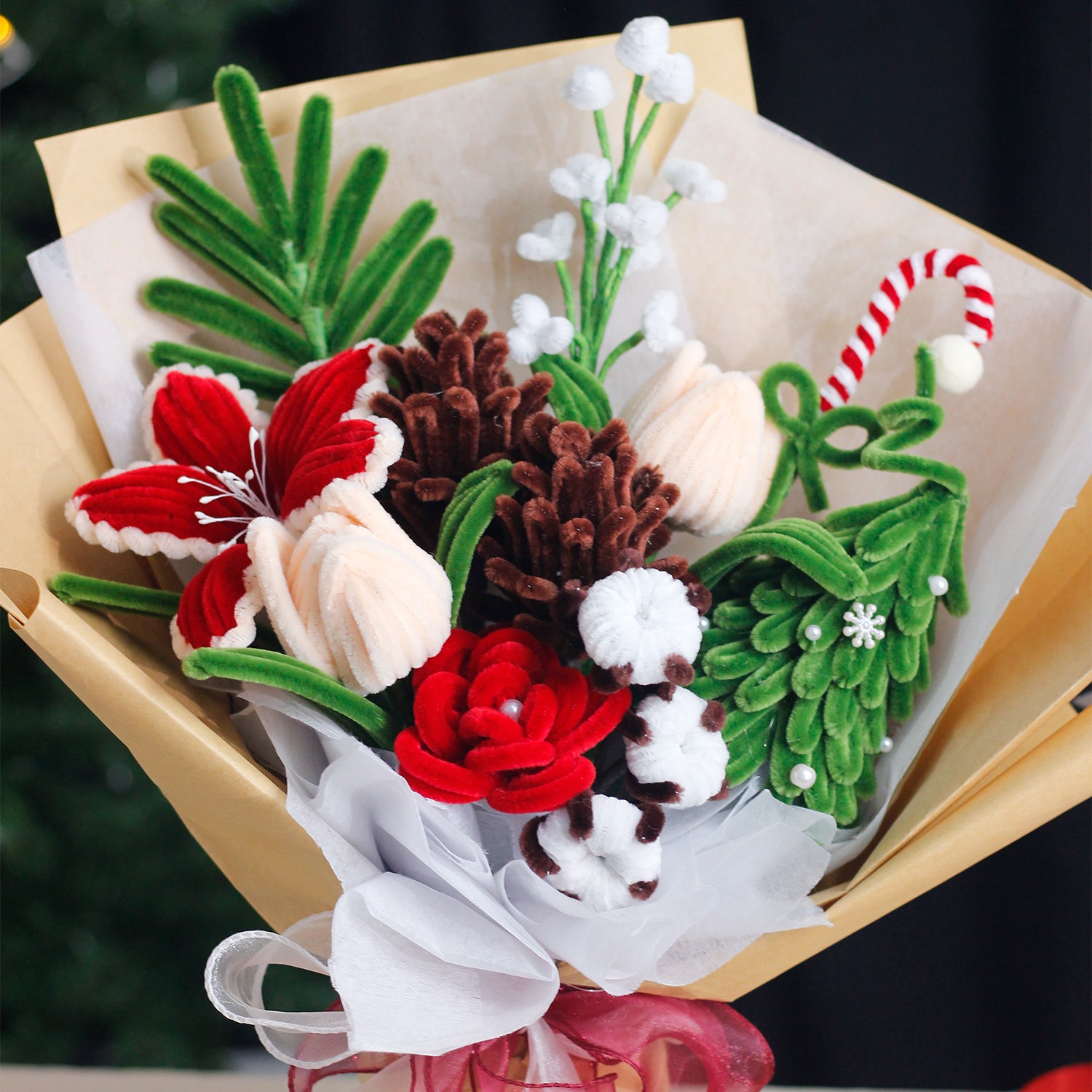 Handmade bouquet of white and blue pipe cleaner flowers wrapped in soft blue and white paper with ribbon. Features lifelike lilies and daisies. A winter-inspired, everlasting floral gift.