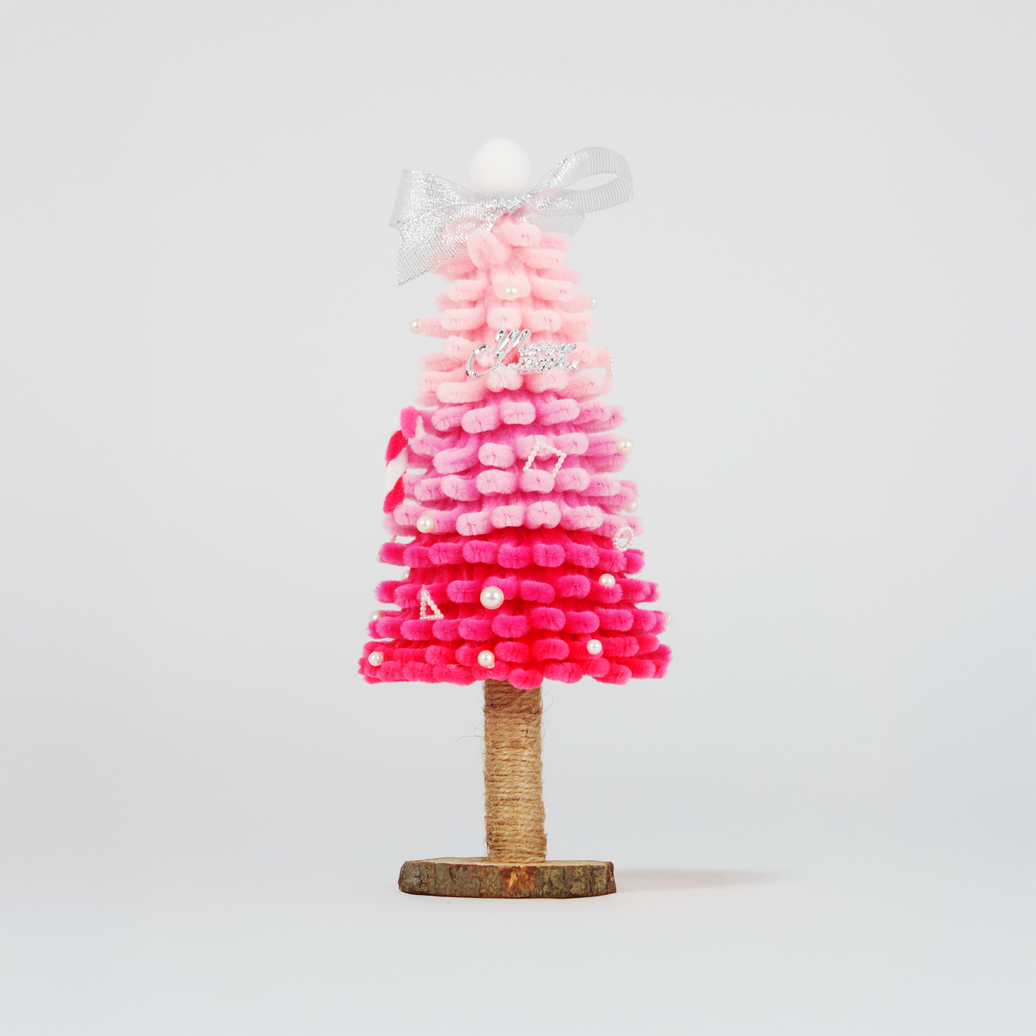 Stylish pink ombré Christmas tree made from soft pipe cleaners, topped with a silver bow – ideal for girly festive decor or handmade gift.