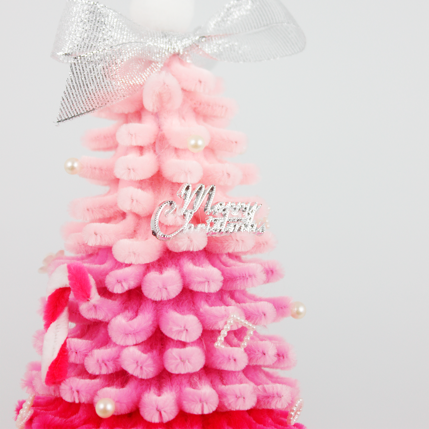 Stylish pink ombré Christmas tree made from soft pipe cleaners, topped with a silver bow – ideal for girly festive decor or handmade gift.