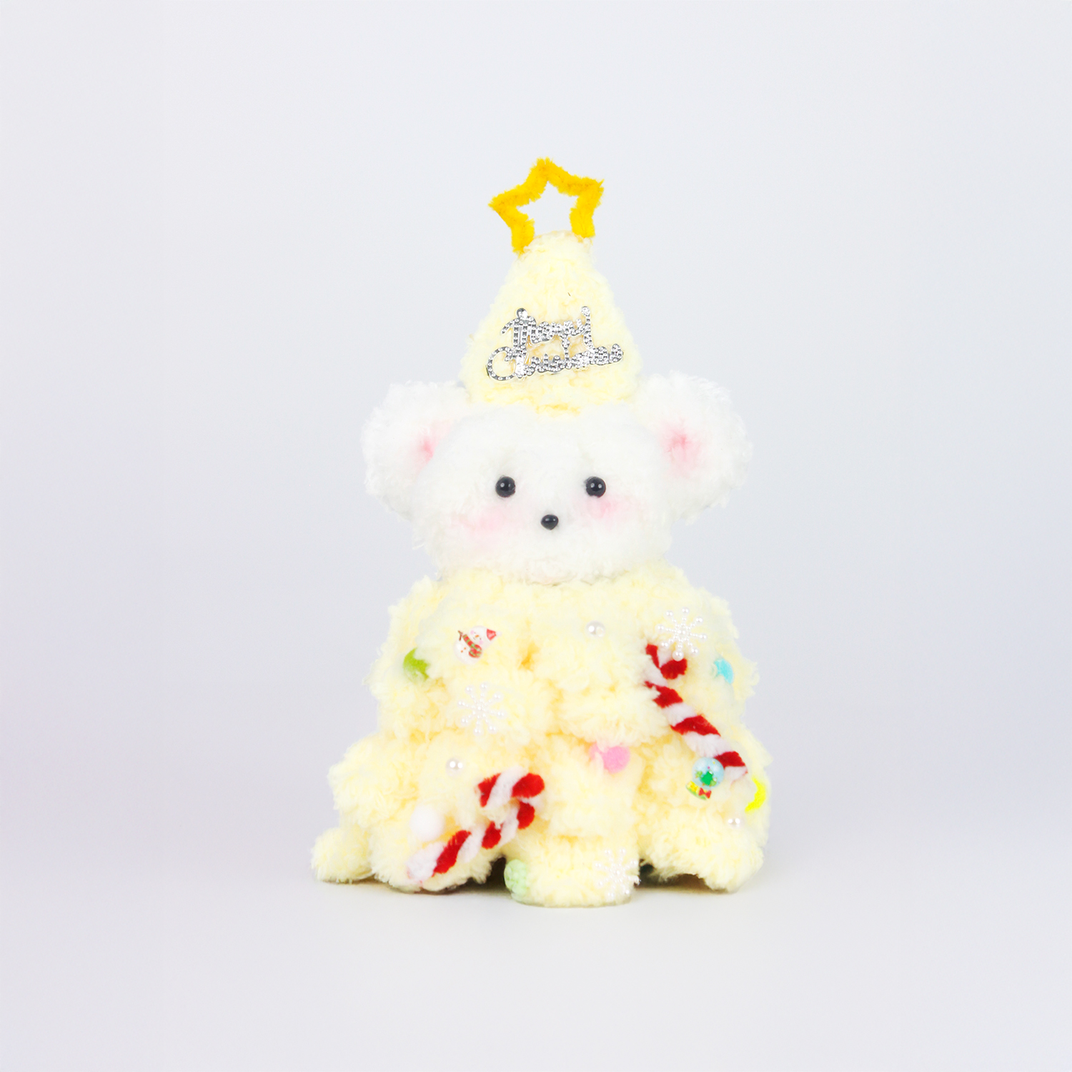 Fuzzy pipe cleaner bear dressed in a bright yellow Christmas tree dress with a star hat — creative handmade Christmas decoration.